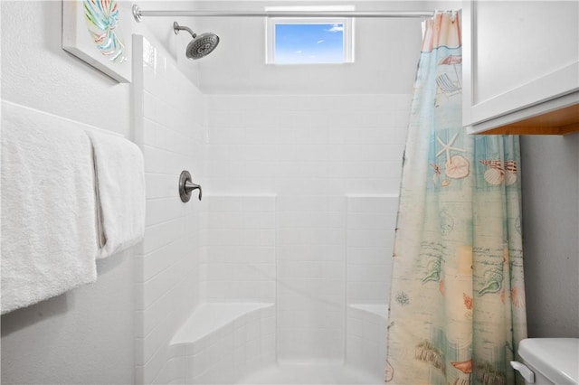 bathroom featuring curtained shower and toilet