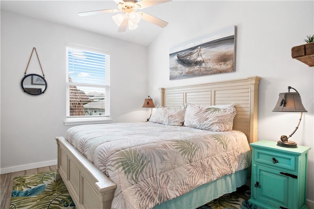 bedroom with ceiling fan, lofted ceiling, baseboards, and wood finished floors