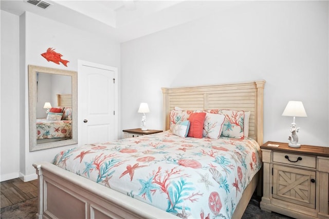 bedroom featuring dark wood finished floors, visible vents, and baseboards