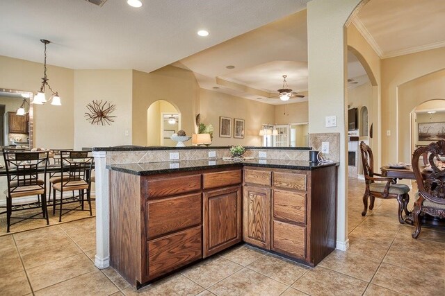214 Palmer Dr, Portland, TX 78374 - kitchen featuring crown molding, arched walkways, ceiling fan, and brown cabinets