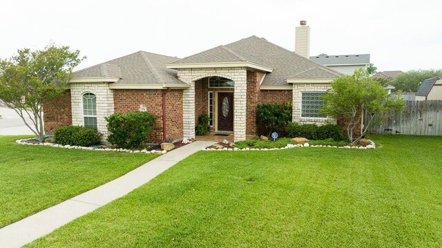 214 Palmer Dr, Portland, TX 78374 - view of front of home featuring fence, a front lawn, roof with shingles, and brick siding