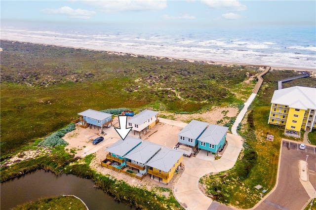 drone / aerial view with a beach view and a water view