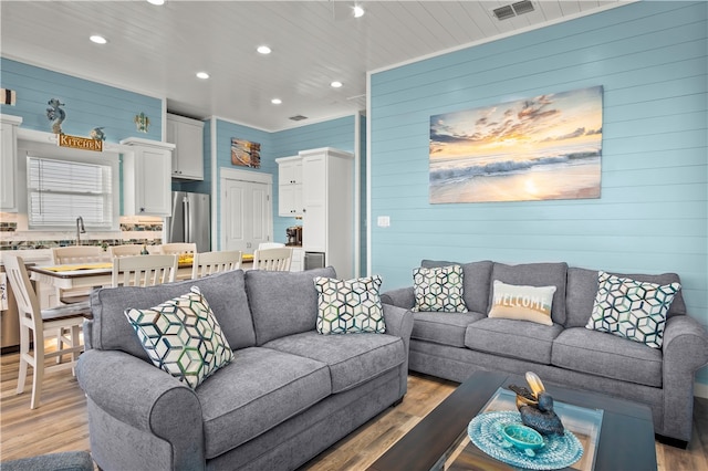 living room featuring light hardwood / wood-style flooring and wooden walls