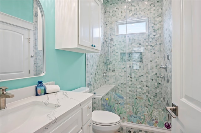 bathroom with tiled shower, vanity, and toilet