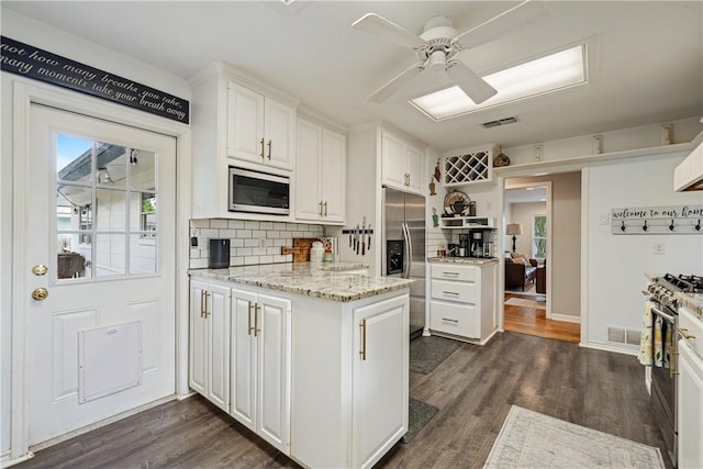622 Bermuda Pl, Corpus Christi, TX 78411 - kitchen with appliances with stainless steel finishes, white cabinets, ceiling fan, decorative backsplash, and dark wood-style floors