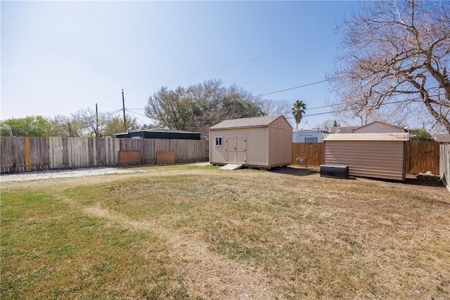 view of yard featuring a shed, an outdoor structure, and a fenced backyard