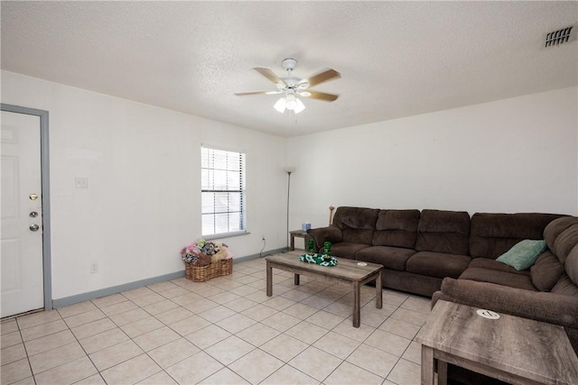 living area with baseboards, ceiling fan, visible vents, and a textured ceiling