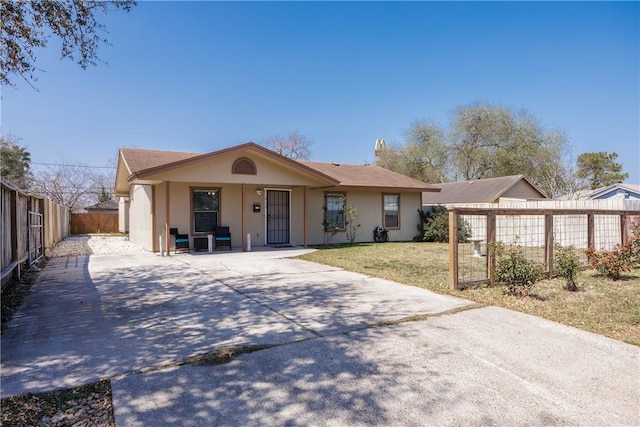 view of front facade featuring fence private yard and a front lawn