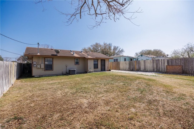 back of house with a lawn, cooling unit, a fenced backyard, and stucco siding