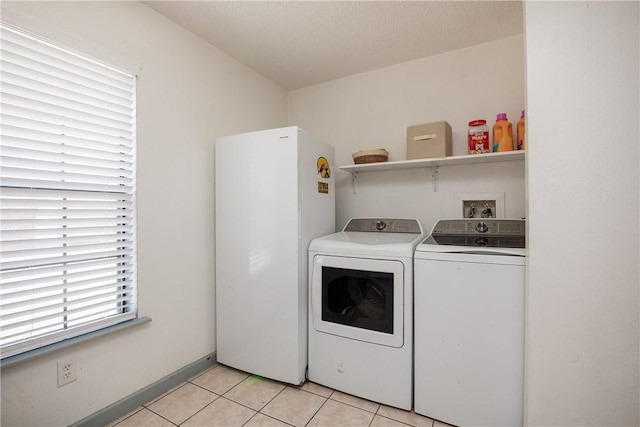 laundry room featuring laundry area, independent washer and dryer, baseboards, and light tile patterned floors