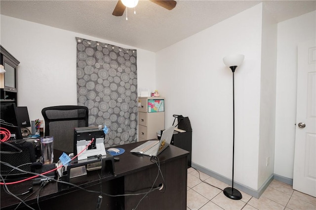 tiled office space with a textured ceiling, a ceiling fan, and baseboards