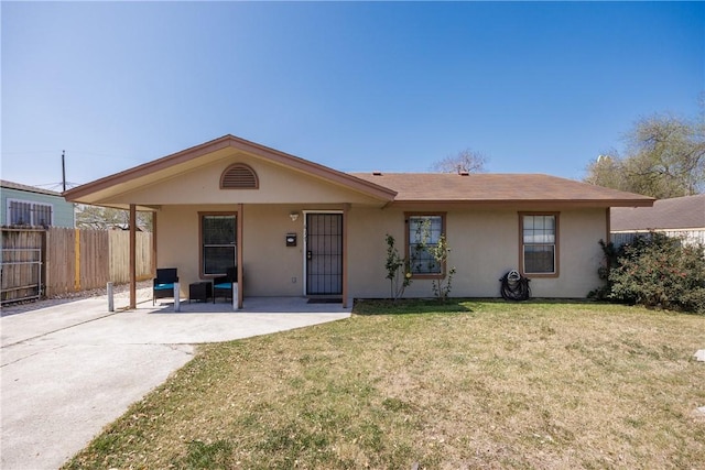 ranch-style home featuring stucco siding, fence, and a front yard