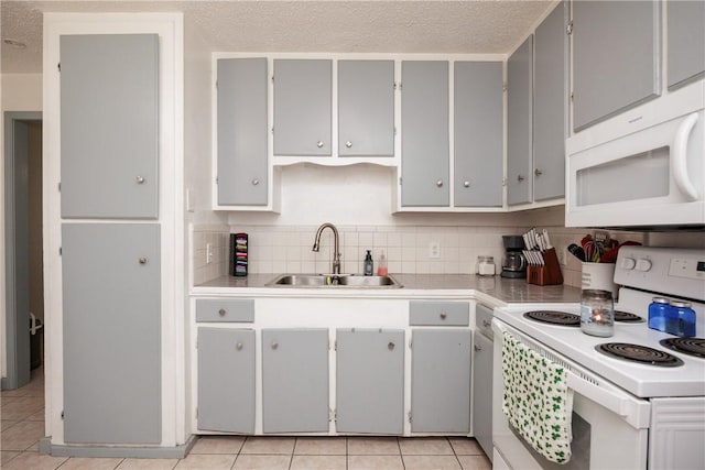 kitchen with white appliances, light countertops, a sink, and gray cabinetry