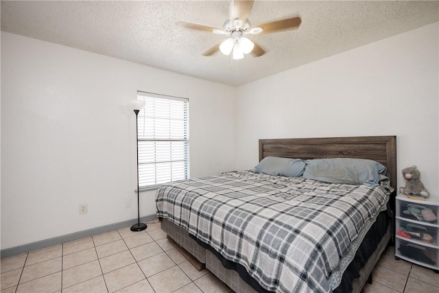 bedroom with a textured ceiling, ceiling fan, light tile patterned flooring, and baseboards