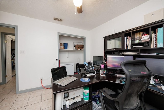 office space with light tile patterned floors, baseboards, visible vents, a ceiling fan, and a textured ceiling