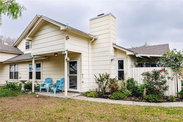 7202 Mansions Dr Unit N1, Corpus Christi, TX 78414 - rear view of house with a chimney, fence, a yard, and a patio
