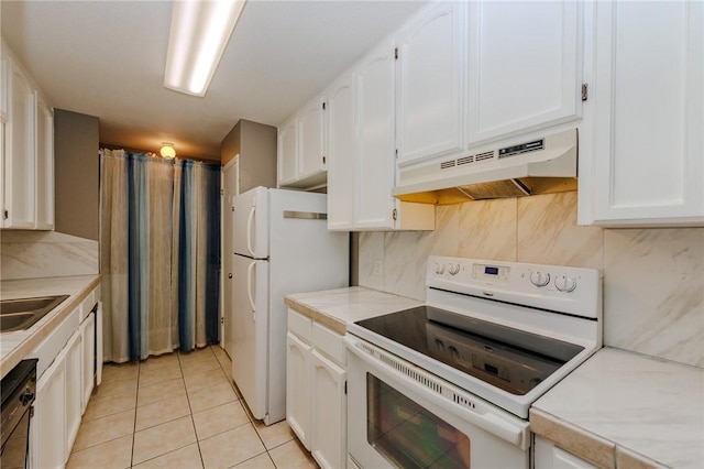 7202 Mansions Dr Unit N1, Corpus Christi, TX 78414 - kitchen with light tile patterned flooring, light countertops, white cabinetry, under cabinet range hood, and white appliances