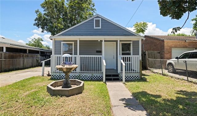 bungalow with a front yard, covered porch, and a garage