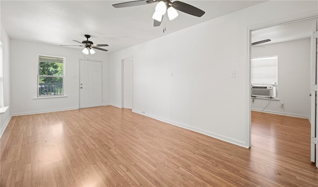 spare room with ceiling fan, cooling unit, and light hardwood / wood-style flooring