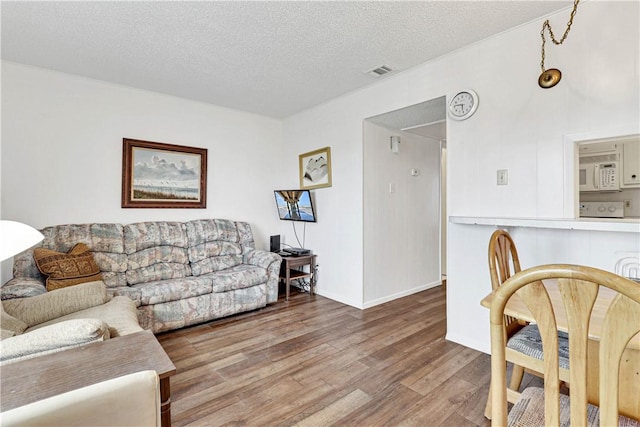 living room with wood-type flooring and a textured ceiling