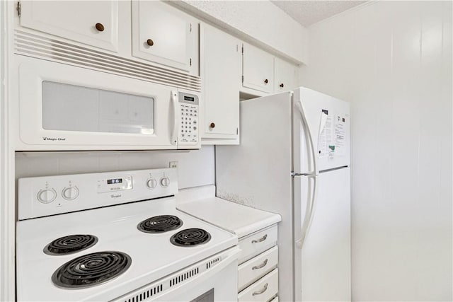 kitchen featuring white cabinets and white appliances