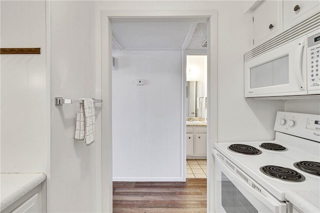 kitchen with light hardwood / wood-style floors, white cabinetry, and white appliances