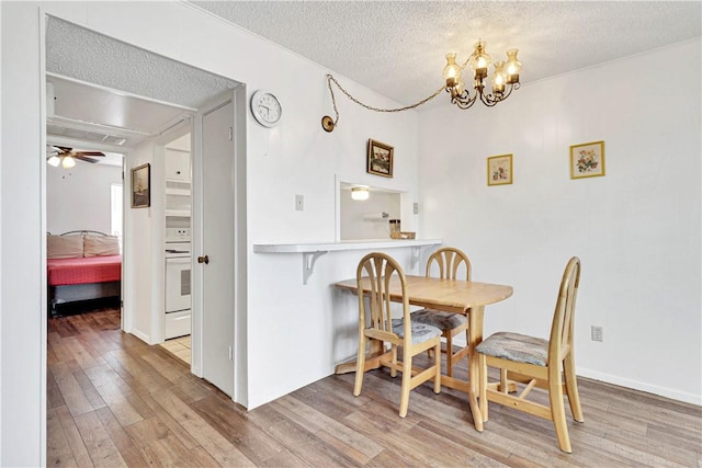 dining area with hardwood / wood-style flooring, ceiling fan with notable chandelier, and a textured ceiling