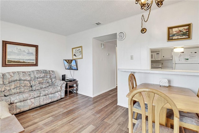 dining space featuring light hardwood / wood-style floors and a textured ceiling