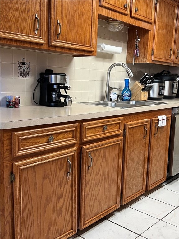 kitchen featuring sink, stainless steel dishwasher, and decorative backsplash