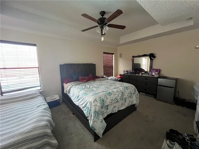 bedroom featuring carpet, a textured ceiling, ceiling fan, and a raised ceiling