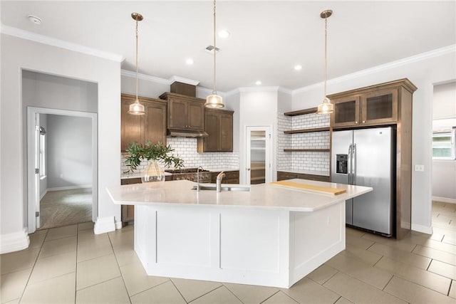 14013 Hawksnest Bay Dr, Corpus Christi, TX 78418 - kitchen with stainless steel fridge with ice dispenser, open shelves, under cabinet range hood, light countertops, and ornamental molding