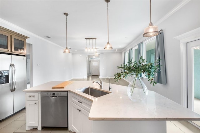 14013 Hawksnest Bay Dr, Corpus Christi, TX 78418 - kitchen featuring stainless steel appliances, a kitchen island with sink, white cabinetry, hanging light fixtures, and crown molding