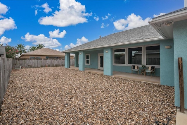 14013 Hawksnest Bay Dr, Corpus Christi, TX 78418 - back of house featuring a fenced backyard, a patio, stucco siding, and roof with shingles