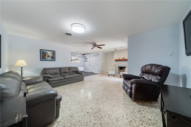 438 Pennington Dr, Corpus Christi, TX 78412 - living room with speckled floor, ceiling fan, and a fireplace