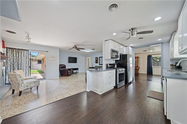 438 Pennington Dr, Corpus Christi, TX 78412 - kitchen featuring appliances with stainless steel finishes, a ceiling fan, open floor plan, white cabinets, and dark countertops