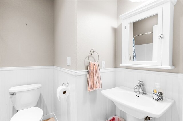 215 Sandollar Cir, Fulton, TX 78358 - bathroom featuring a wainscoted wall, toilet, a sink, and a shower with shower curtain