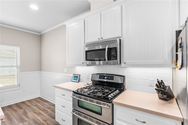 215 Sandollar Cir, Fulton, TX 78358 - kitchen featuring stainless steel appliances, white cabinets, light countertops, light wood-type flooring, and crown molding