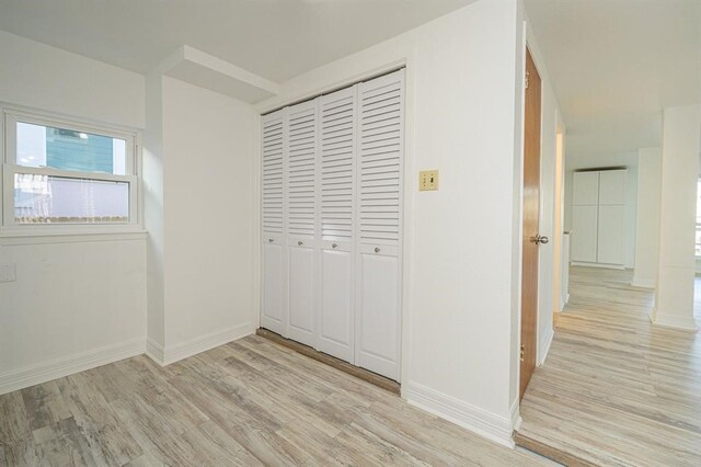 unfurnished bedroom with light hardwood / wood-style flooring and a closet