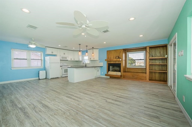 kitchen featuring white cabinetry, sink, tasteful backsplash, decorative light fixtures, and white appliances