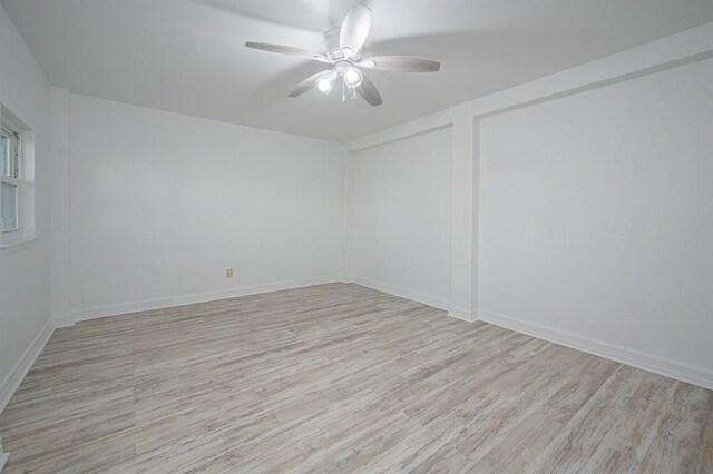 empty room with ceiling fan and light hardwood / wood-style flooring