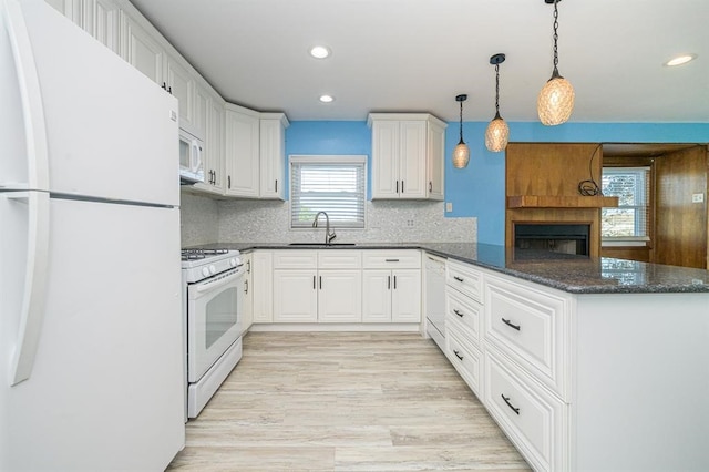 kitchen featuring white cabinets, pendant lighting, white appliances, and sink