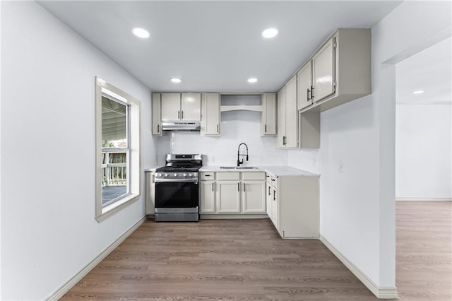 1122 Dorthy Dr, Corpus Christi, TX 78412 - kitchen with gas range, under cabinet range hood, a sink, backsplash, and recessed lighting