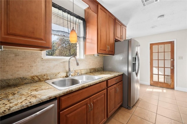 kitchen featuring decorative light fixtures, sink, appliances with stainless steel finishes, light tile patterned flooring, and decorative backsplash