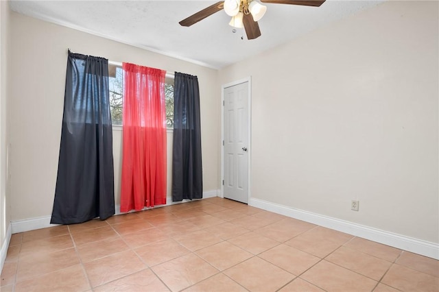 tiled spare room with ceiling fan