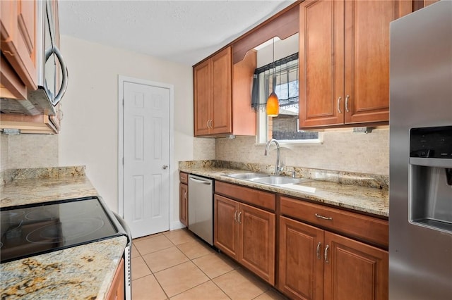 kitchen featuring sink, light tile patterned flooring, light stone countertops, and stainless steel appliances