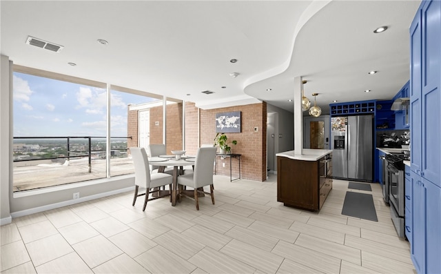 715 S Upper Broadway St Unit 1501, Corpus Christi, TX 78401 - kitchen featuring stainless steel refrigerator with ice dispenser, a center island, light countertops, blue cabinets, and extractor fan