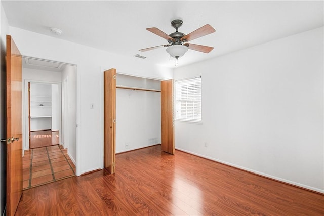 unfurnished bedroom with hardwood / wood-style floors, a closet, and ceiling fan