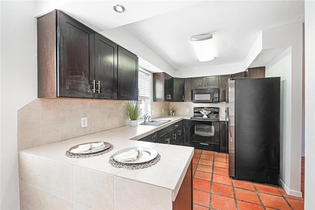 kitchen featuring dark brown cabinetry, sink, tasteful backsplash, light tile patterned floors, and black appliances