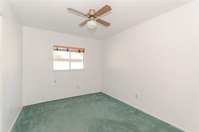 spare room with ceiling fan and dark carpet