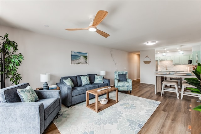 living room featuring wood-type flooring and ceiling fan